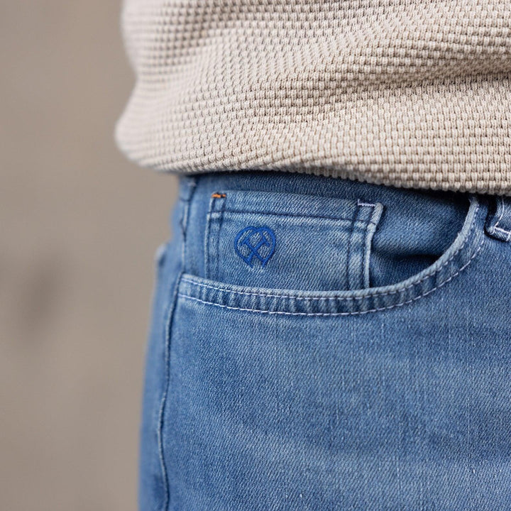 Detail van een Delft Denim jeans – close-up van de coin pocket met geborduurd logo. Gemaakt van duurzame denim met een tijdloos design en perfecte pasvorm.