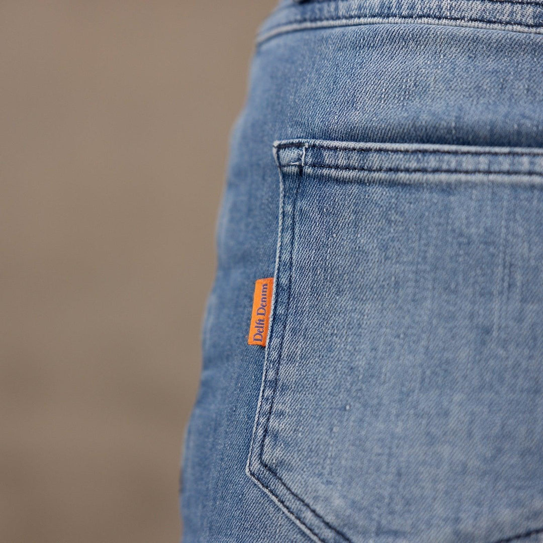 Detail van The Slim jeans van Delft Denim – achterzak met oranje merklabel. Duurzame heren spijkerbroek van biologisch en gerecycled katoen met tijdloos design.