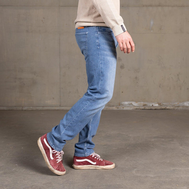 Man loopt in The Straight jeans van Delft Denim – een duurzame heren spijkerbroek met rechte pasvorm. Gemaakt van biologisch en gerecycled katoen voor ultiem comfort.